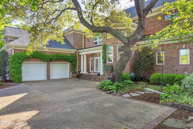view of front facade with an attached garage, brick siding, and driveway