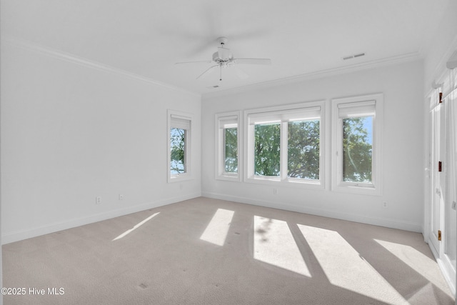 unfurnished room featuring ornamental molding, visible vents, ceiling fan, light carpet, and baseboards