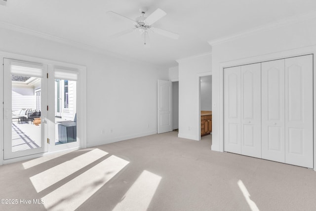 unfurnished bedroom featuring light colored carpet, crown molding, ceiling fan, baseboards, and access to exterior