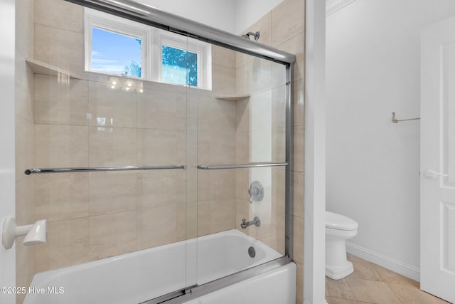full bath featuring toilet, baseboards, tile patterned floors, and bath / shower combo with glass door
