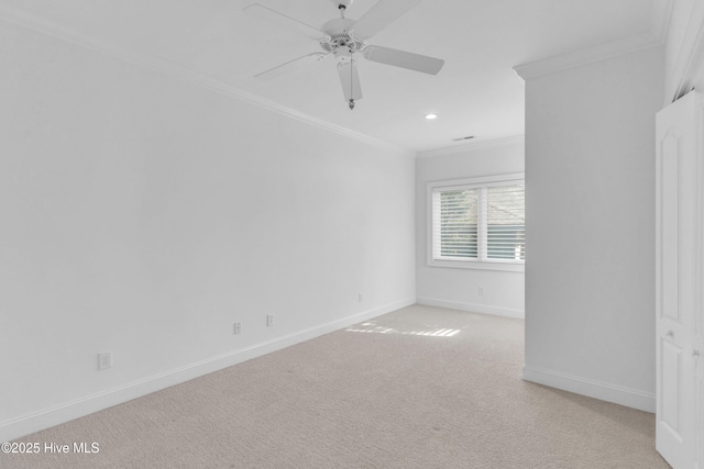 spare room featuring light colored carpet, ornamental molding, recessed lighting, a ceiling fan, and baseboards