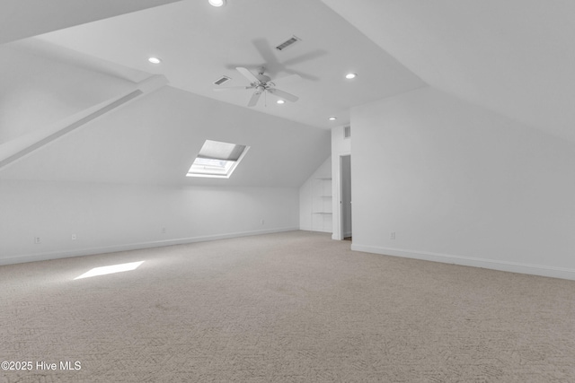 bonus room featuring vaulted ceiling with skylight, recessed lighting, ceiling fan, light carpet, and baseboards