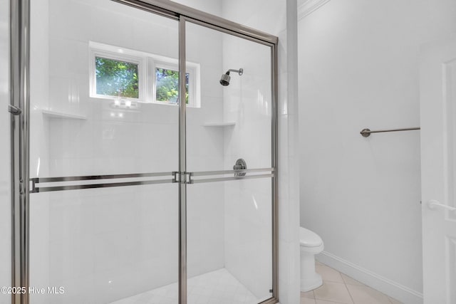 full bath featuring toilet, baseboards, tile patterned flooring, and a shower stall
