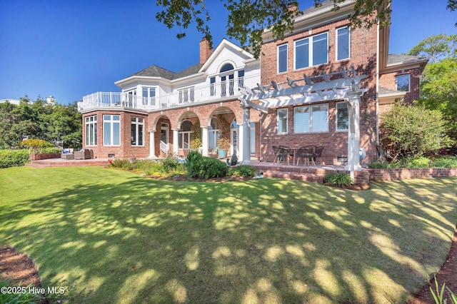 view of front facade with brick siding, a pergola, a patio area, and a balcony