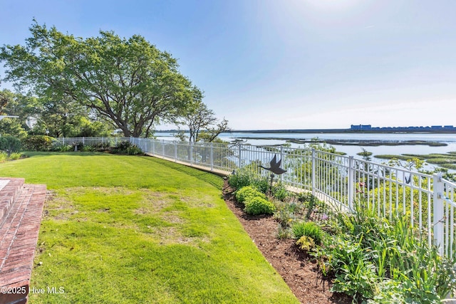 view of yard featuring a water view and a fenced backyard
