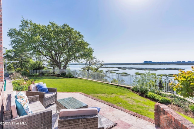 view of patio / terrace with outdoor lounge area, a water view, and a fenced backyard