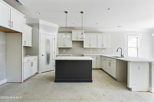 kitchen with sink, a center island, tasteful backsplash, decorative light fixtures, and kitchen peninsula