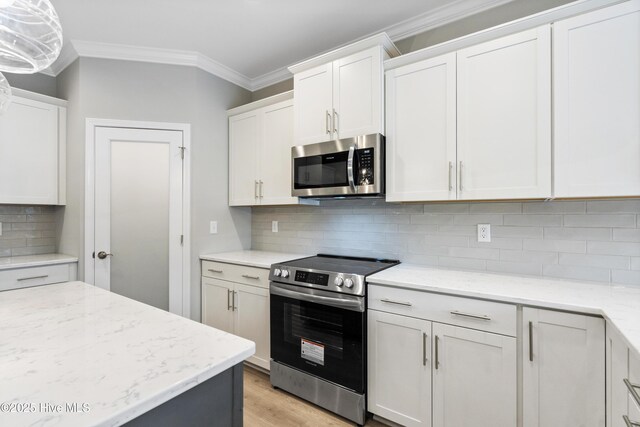 kitchen featuring stainless steel appliances, light countertops, a kitchen island with sink, a sink, and white cabinetry