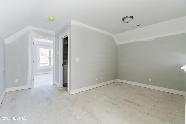 empty room featuring vaulted ceiling