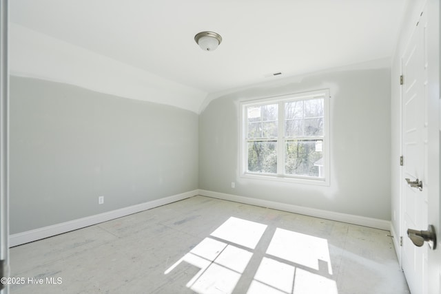 unfurnished room with lofted ceiling