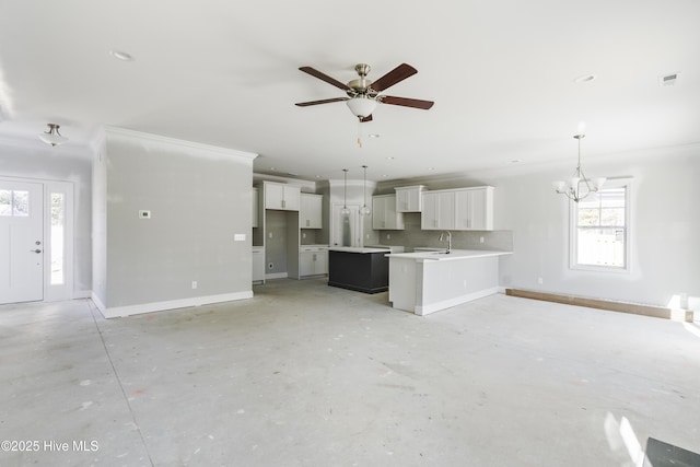 interior space featuring white cabinetry, ceiling fan with notable chandelier, sink, and hanging light fixtures