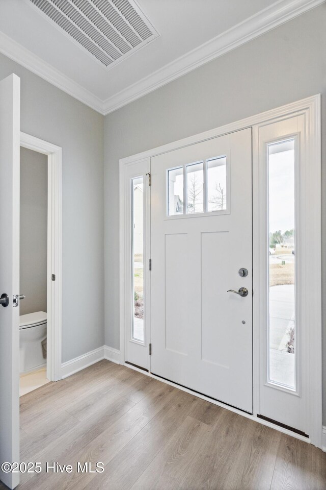 doorway to property with stone siding, a porch, a lawn, and roof with shingles