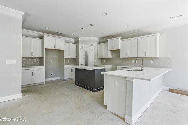 kitchen featuring pendant lighting, sink, white cabinets, a kitchen island, and kitchen peninsula