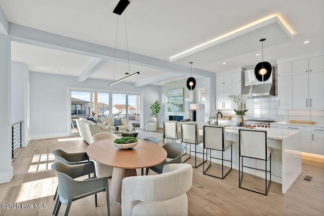 dining area featuring light wood-type flooring, beamed ceiling, baseboards, visible vents, and recessed lighting
