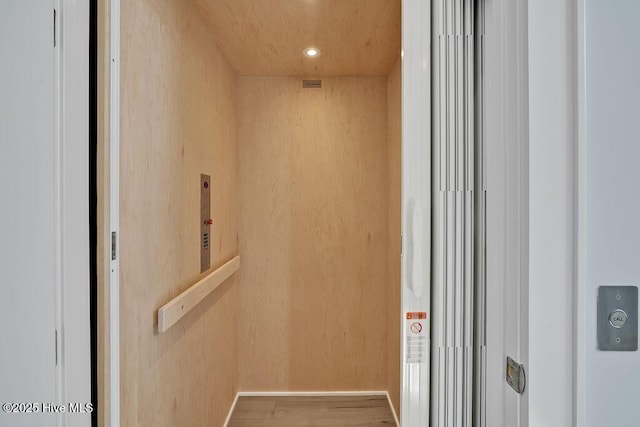 details with baseboards, elevator, wood finished floors, and recessed lighting