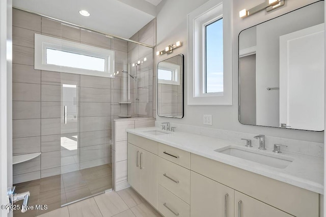 bathroom with tile patterned flooring, double vanity, a sink, and a walk in shower