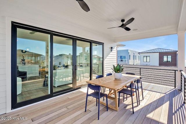 wooden deck featuring outdoor dining area and a ceiling fan