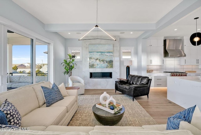 living room featuring a glass covered fireplace and light wood-style flooring