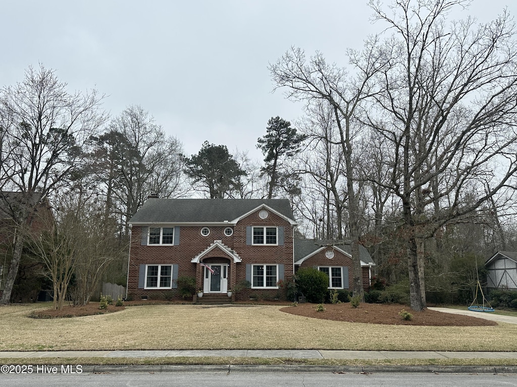 view of front facade featuring brick siding and a front lawn