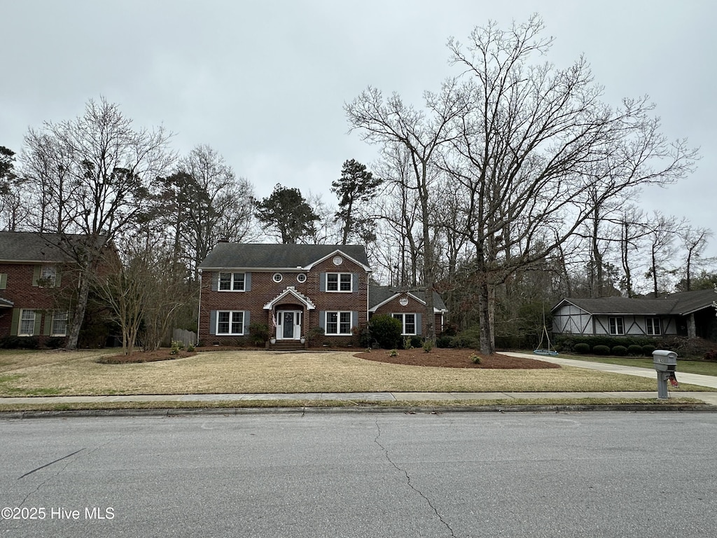 view of front of home featuring concrete driveway and a front lawn