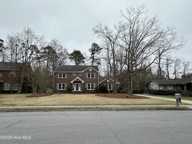 view of front of home featuring concrete driveway and a front lawn