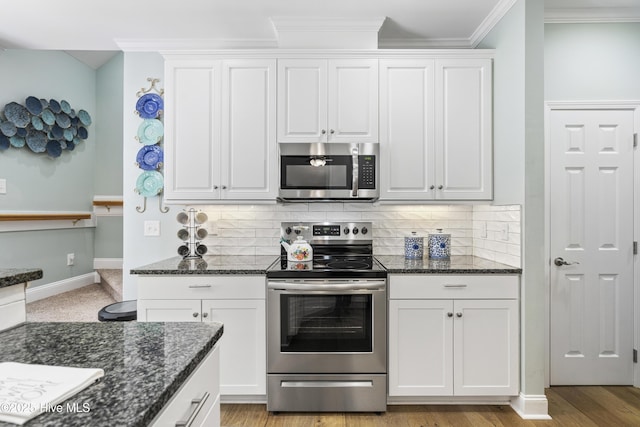 kitchen featuring appliances with stainless steel finishes, white cabinets, and backsplash