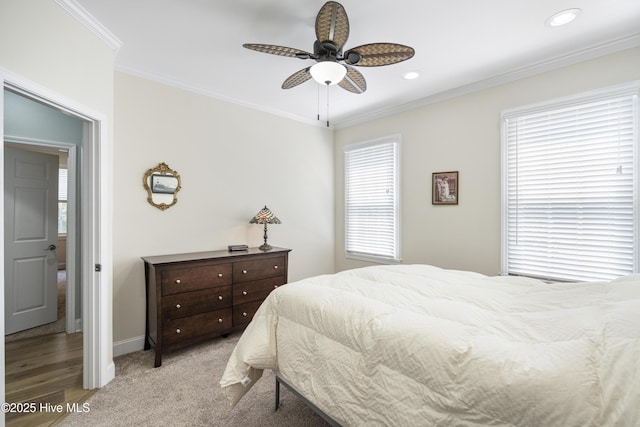 carpeted bedroom with crown molding and ceiling fan