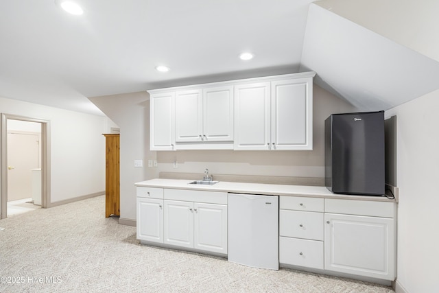 kitchen with sink, dishwasher, white cabinetry, light carpet, and vaulted ceiling