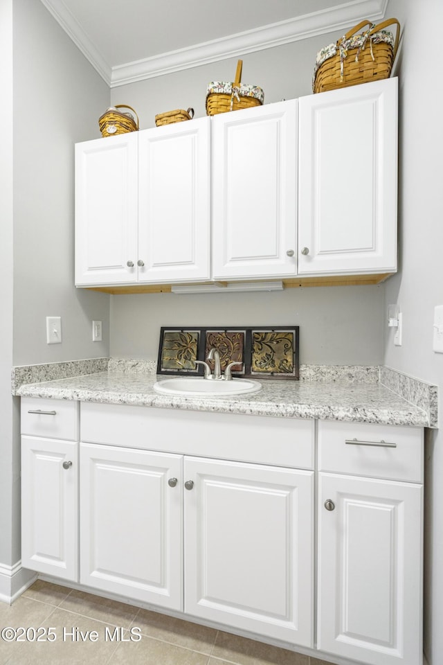 laundry room with crown molding, sink, and light tile patterned floors