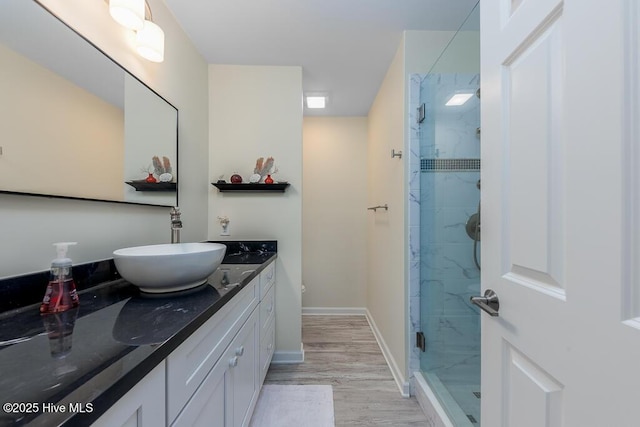 bathroom featuring an enclosed shower, vanity, and hardwood / wood-style floors