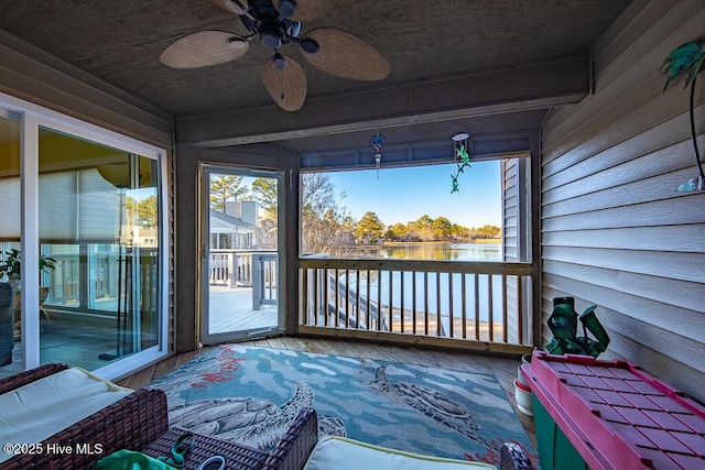 sunroom featuring a wealth of natural light, beamed ceiling, ceiling fan, and a water view