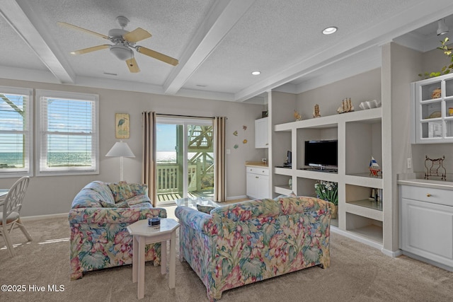 carpeted living room with ceiling fan, a textured ceiling, and beamed ceiling