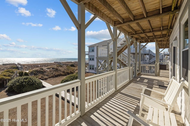 deck with a water view and a beach view