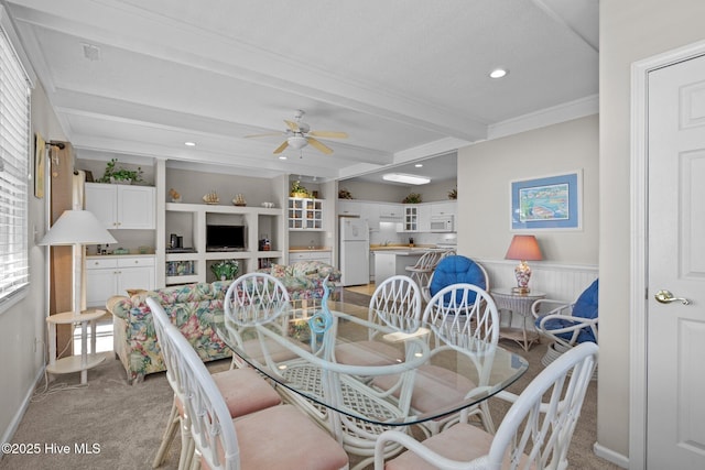 carpeted dining area featuring crown molding, beam ceiling, and ceiling fan