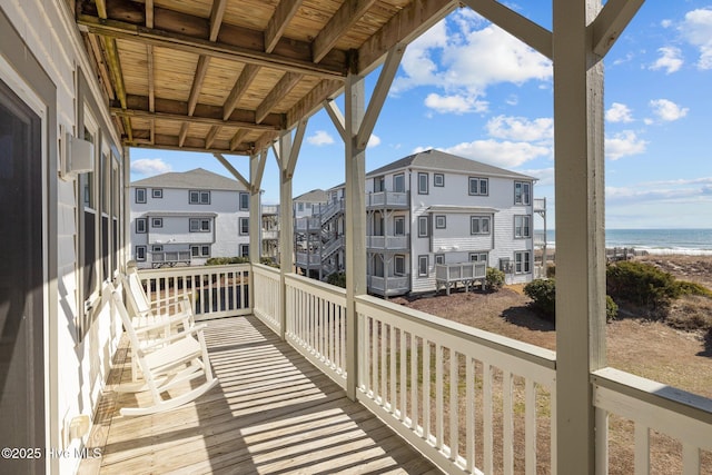 balcony featuring a beach view and a water view