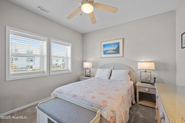 bedroom with ceiling fan, carpet, and a textured ceiling