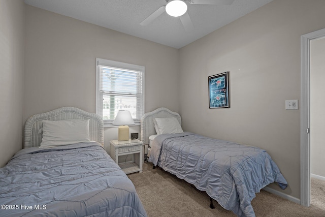 bedroom featuring light carpet, a textured ceiling, and ceiling fan