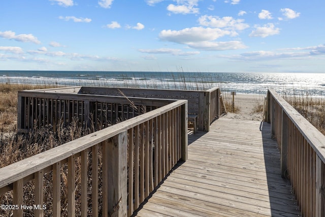 view of property's community with a water view and a view of the beach