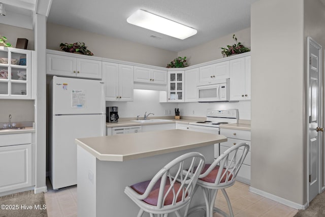 kitchen with white cabinetry, white appliances, and sink