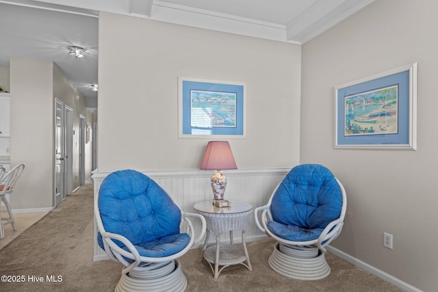 sitting room featuring ornamental molding and carpet flooring