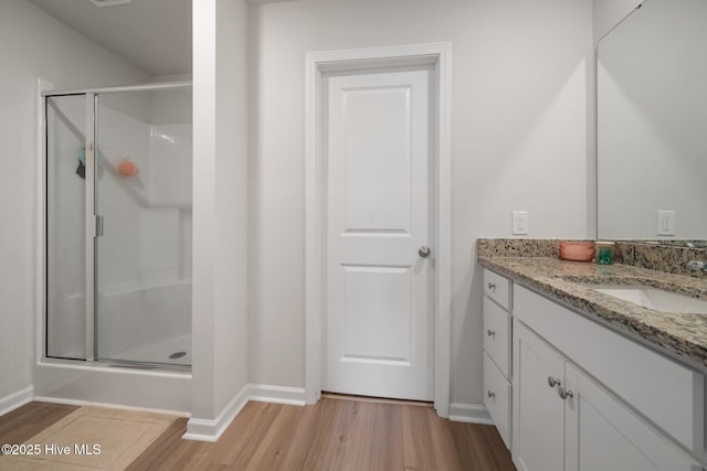 bathroom with vanity, hardwood / wood-style flooring, and a shower with shower door