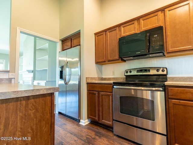 kitchen with brown cabinets, stainless steel appliances, dark wood finished floors, and light countertops