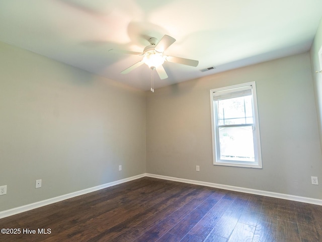 unfurnished room with baseboards, ceiling fan, dark wood-style flooring, and visible vents