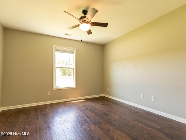 unfurnished room featuring baseboards, visible vents, ceiling fan, and dark wood-type flooring