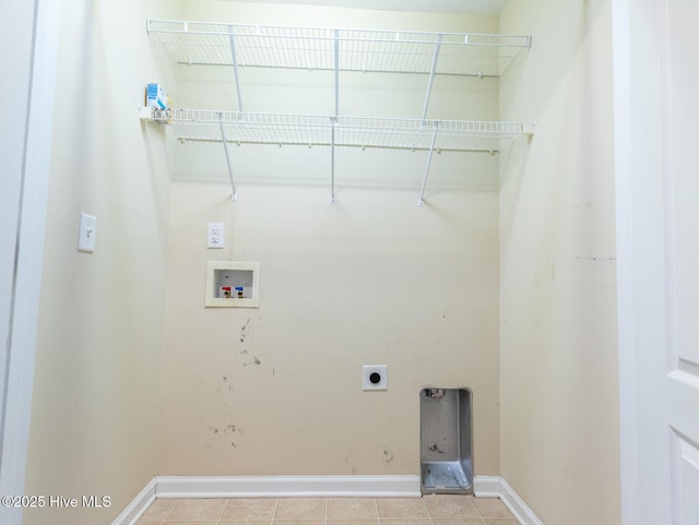 laundry room featuring electric dryer hookup, washer hookup, light tile patterned floors, and baseboards