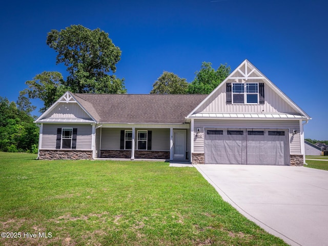 craftsman-style home featuring a front yard, stone siding, board and batten siding, a porch, and driveway