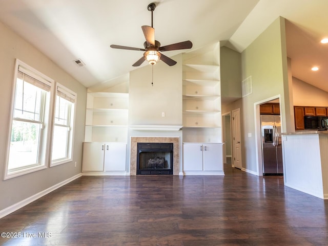 unfurnished living room featuring a ceiling fan, visible vents, lofted ceiling, and dark wood-type flooring