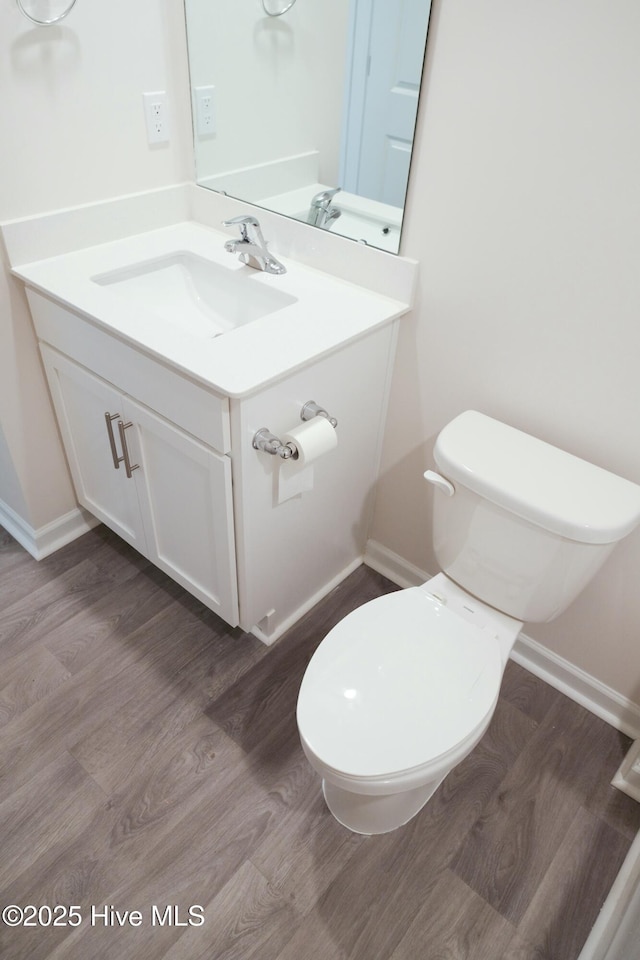 bathroom with hardwood / wood-style flooring, vanity, and toilet