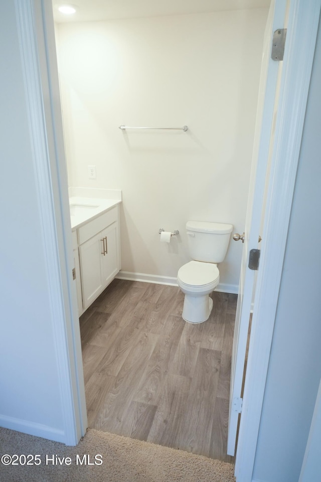 bathroom featuring vanity, toilet, and hardwood / wood-style floors