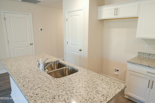 kitchen featuring white cabinetry and a kitchen island with sink